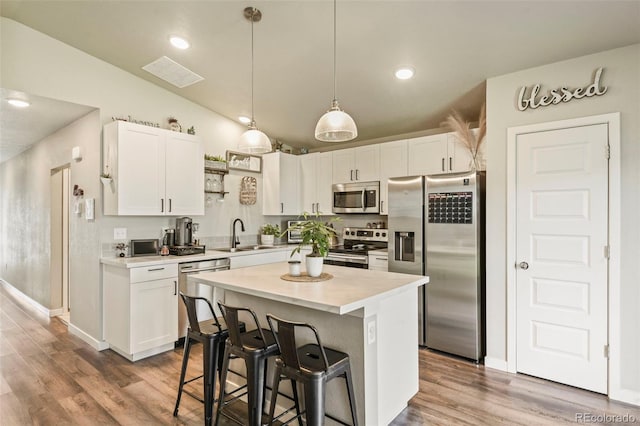 719 S Hoover Ave, Fort Lupton, CO 80621 - kitchen featuring stainless steel appliances, a sink, vaulted ceiling, white cabinetry, and light countertops