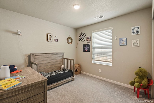 719 S Hoover Ave, Fort Lupton, CO 80621 - bedroom featuring carpet, a crib, baseboards, and a textured ceiling