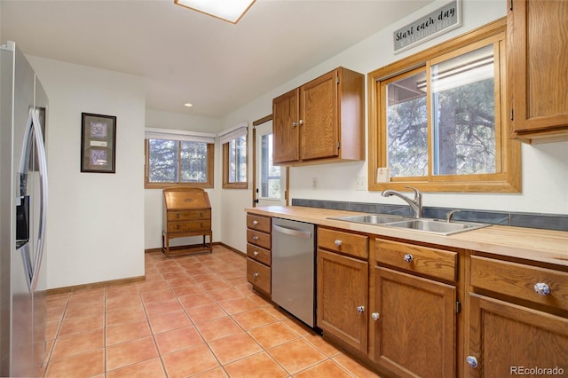 kitchen with appliances with stainless steel finishes, light tile patterned floors, and sink