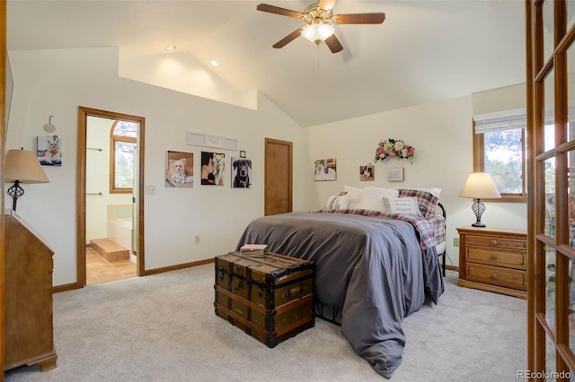 bedroom featuring ensuite bath, ceiling fan, light colored carpet, and vaulted ceiling