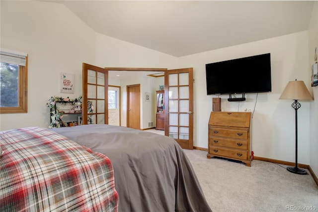 bedroom featuring multiple windows, french doors, carpet floors, and lofted ceiling