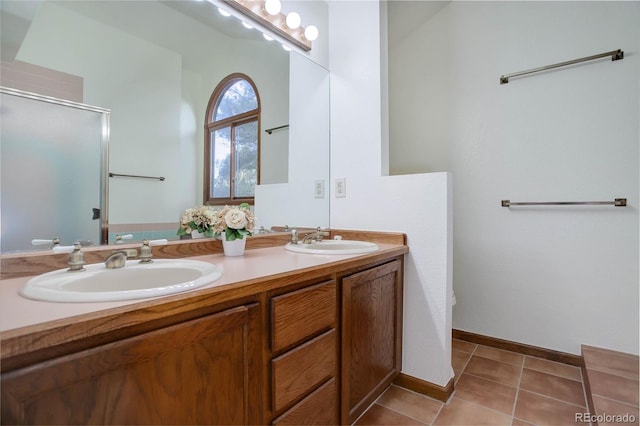 bathroom with tile patterned floors, vanity, a shower with shower door, and toilet