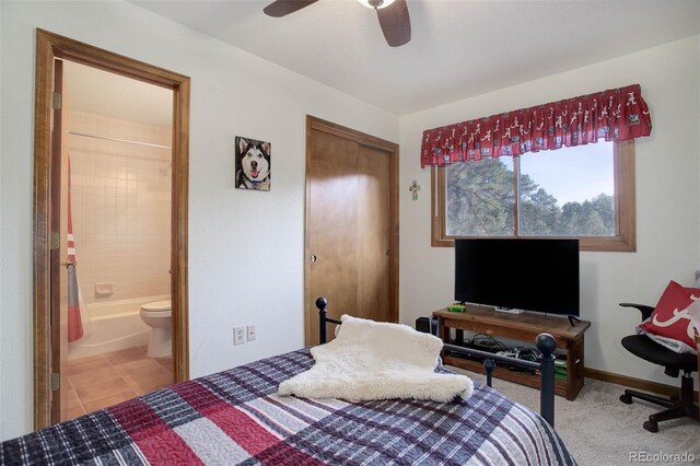 tiled bedroom with connected bathroom and ceiling fan