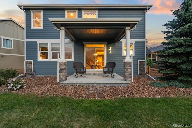 19067 W 57th Dr, Golden, CO 80403 - rear view of property featuring a patio, stone siding, and a yard