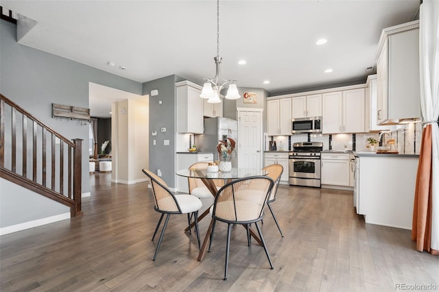 19067 W 57th Dr, Golden, CO 80403 - dining space featuring dark wood finished floors, recessed lighting, stairway, and a chandelier