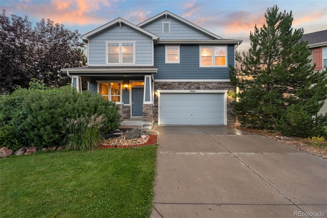19067 W 57th Dr, Golden, CO 80403 - craftsman house featuring stone siding, concrete driveway, a garage, covered porch, and a front yard