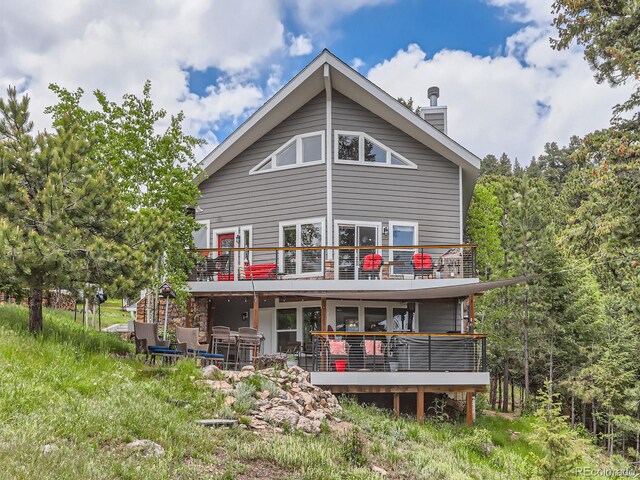 7273 Silverhorn Dr, Evergreen, CO 80439 - rear view of house with a balcony and a chimney
