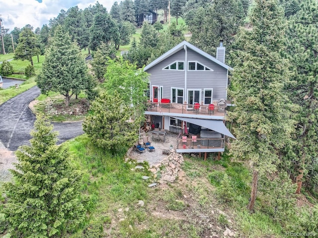 7273 Silverhorn Dr, Evergreen, CO 80439 - rear view of property featuring a patio area, a wooden deck, a chimney, and view of scattered trees