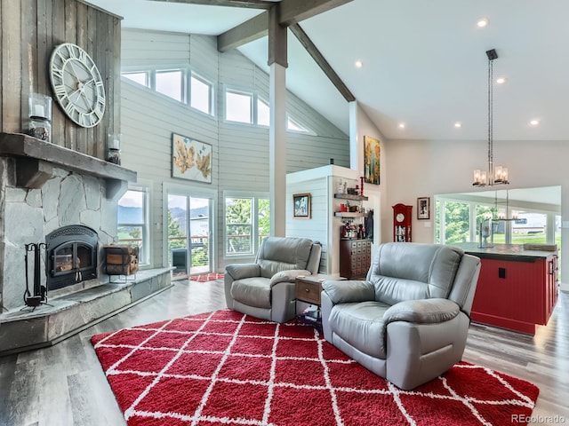 7273 Silverhorn Dr, Evergreen, CO 80439 - living room featuring high vaulted ceiling, a chandelier, wood finished floors, a fireplace, and healthy amount of natural light