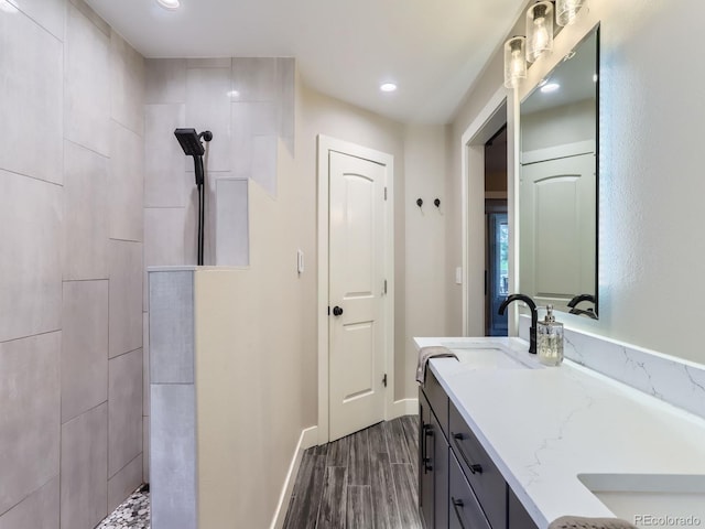 7273 Silverhorn Dr, Evergreen, CO 80439 - full bath with vanity, a tile shower, wood finished floors, baseboards, and recessed lighting