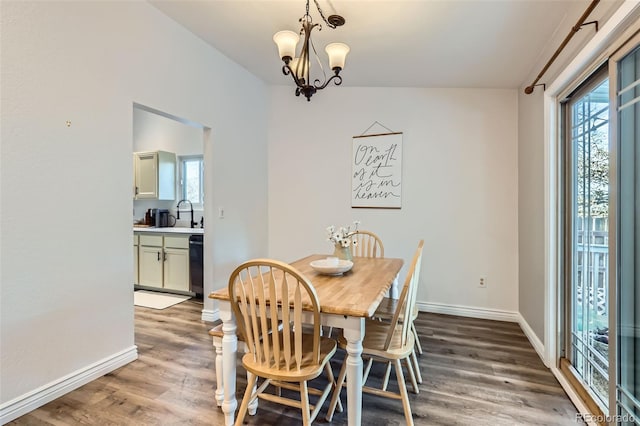 dining room with an inviting chandelier, wood-type flooring, sink, and a wealth of natural light