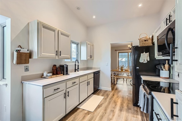 kitchen featuring dishwasher, sink, stainless steel range with electric cooktop, and a healthy amount of sunlight