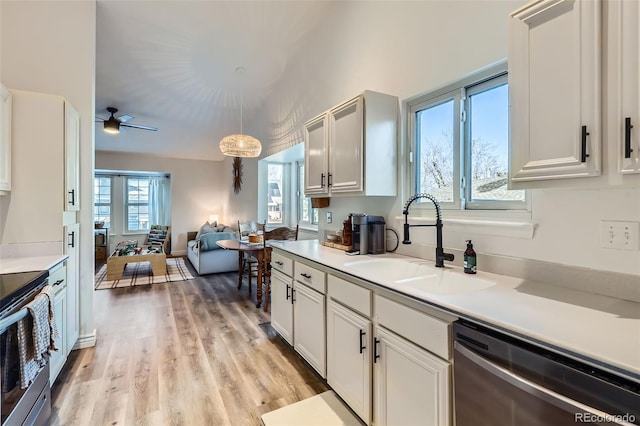 kitchen with white cabinetry, appliances with stainless steel finishes, sink, and hanging light fixtures