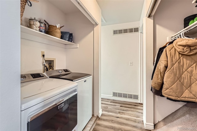 washroom featuring washing machine and clothes dryer and light wood-type flooring