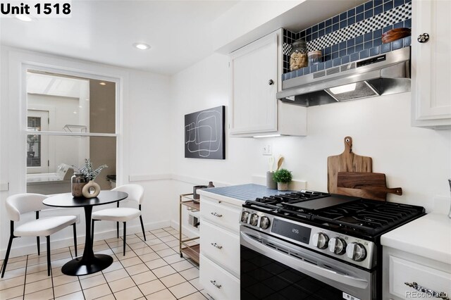 kitchen featuring gas range, light countertops, white cabinets, recessed lighting, and light tile patterned flooring