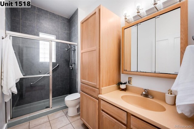 full bath featuring vanity, toilet, tile patterned flooring, and a stall shower