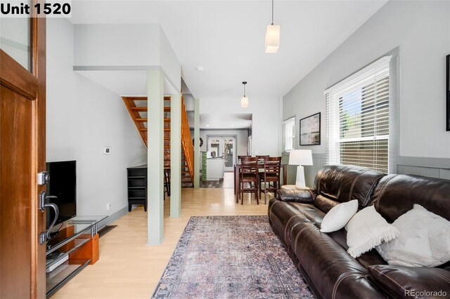 living room featuring stairs and light wood-type flooring