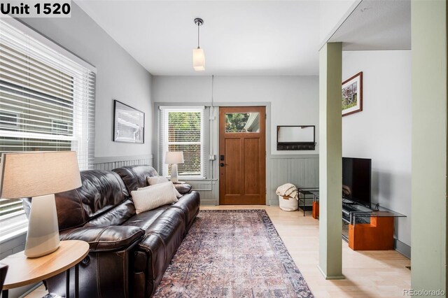 living area with light wood finished floors and wainscoting