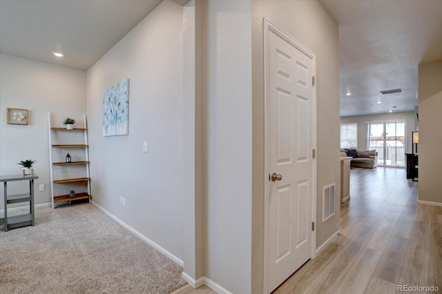 hall featuring visible vents and baseboards