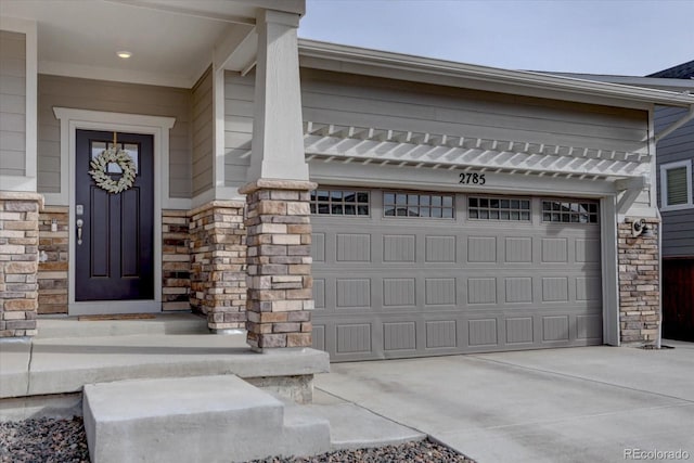 2785 Black Hawk Pl, Brighton, CO 80601 - view of exterior entry with stone siding, concrete driveway, and a garage