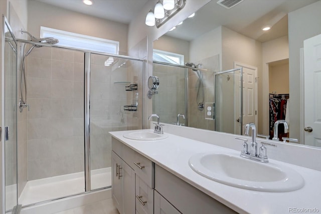 2785 Black Hawk Pl, Brighton, CO 80601 - bathroom featuring a shower stall, double vanity, a walk in closet, and recessed lighting