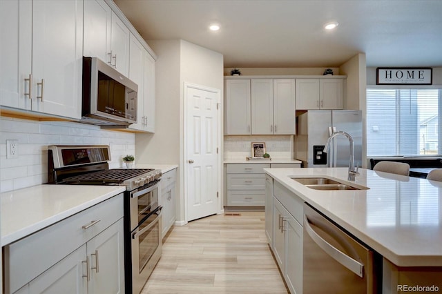 2785 Black Hawk Pl, Brighton, CO 80601 - kitchen featuring stainless steel appliances, a sink, decorative backsplash, a center island with sink, and light countertops