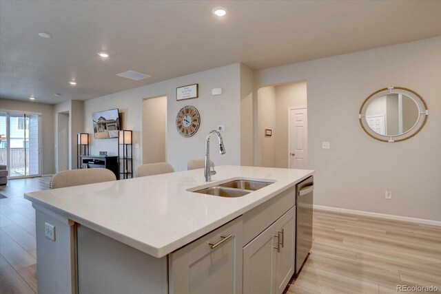 2785 Black Hawk Pl, Brighton, CO 80601 - kitchen with a sink, stainless steel dishwasher, light wood finished floors, a kitchen island with sink, and light countertops