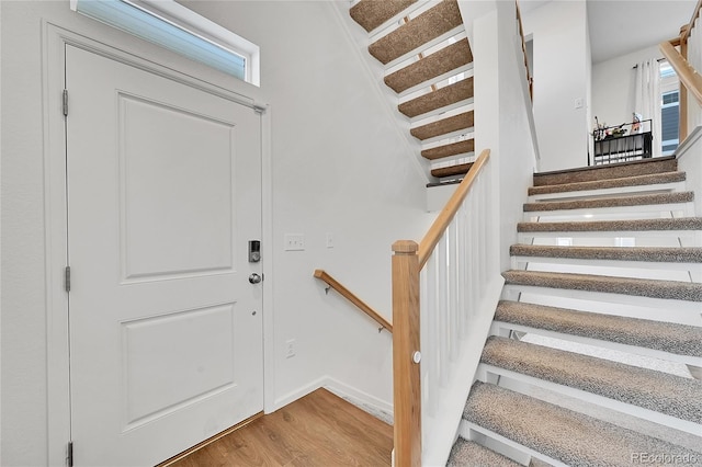 staircase with hardwood / wood-style flooring and plenty of natural light