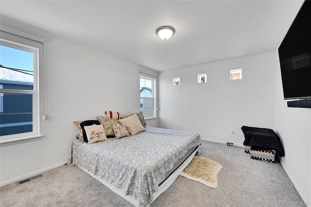 carpeted bedroom featuring multiple windows