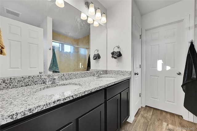 bathroom featuring vanity, hardwood / wood-style floors, and a shower with shower door