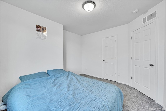 bedroom with carpet and a textured ceiling