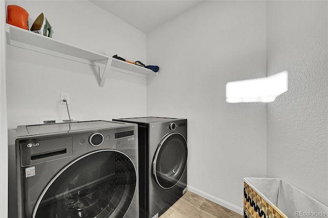 laundry room featuring light wood-type flooring and washing machine and clothes dryer