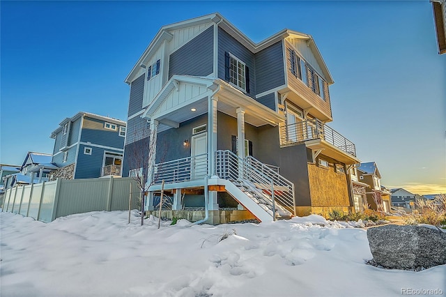 4072 N Rome St, Aurora, CO 80019 - snow covered rear of property with stairway, covered porch, and board and batten siding