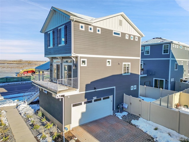 4072 N Rome St, Aurora, CO 80019 - rear view of house featuring board and batten siding, a garage, decorative driveway, and a balcony