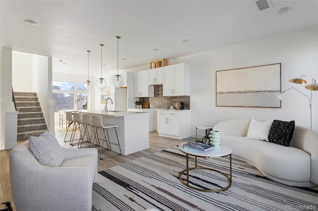 living room with sink and light hardwood / wood-style floors