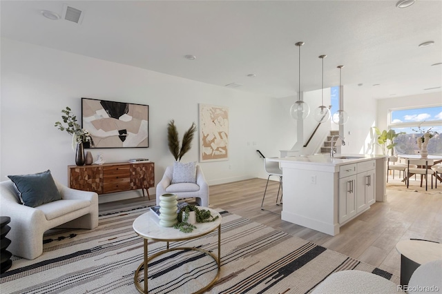 living room featuring sink and light wood-type flooring