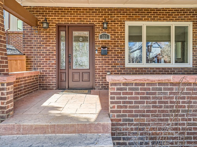 doorway to property featuring brick siding