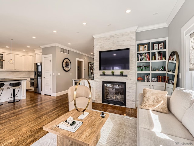 living room featuring visible vents, ornamental molding, dark wood-style flooring, and a stone fireplace