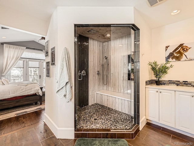 ensuite bathroom featuring ensuite bathroom, a stall shower, visible vents, and wood tiled floor