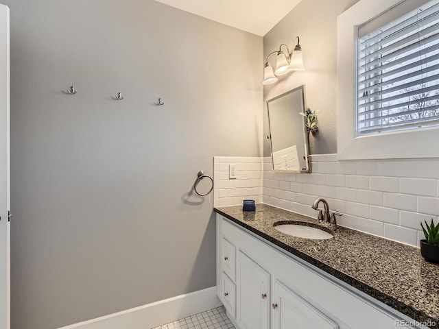 bathroom with tile patterned flooring, baseboards, backsplash, and vanity