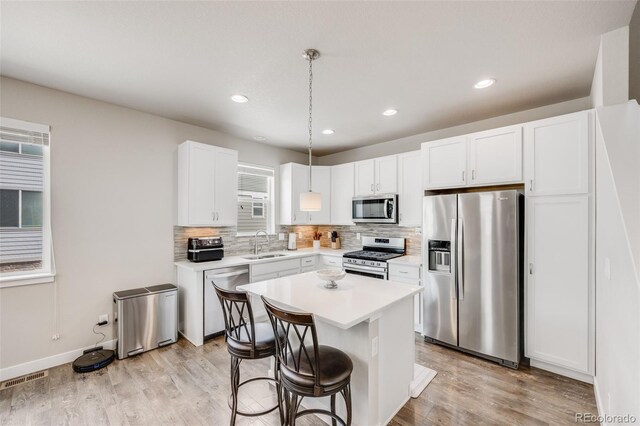 kitchen featuring appliances with stainless steel finishes, a sink, light countertops, decorative backsplash, and recessed lighting