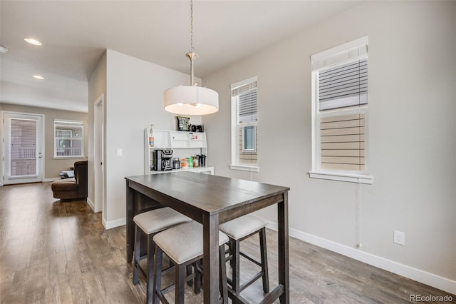 dining space with wood finished floors, baseboards, and recessed lighting