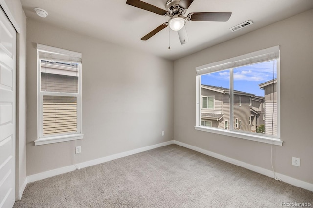 empty room with carpet flooring, baseboards, and a ceiling fan