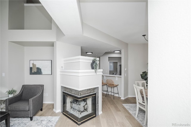 interior space featuring a multi sided fireplace and light hardwood / wood-style floors