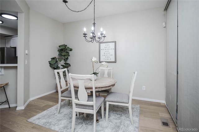 dining space with a chandelier and light hardwood / wood-style floors