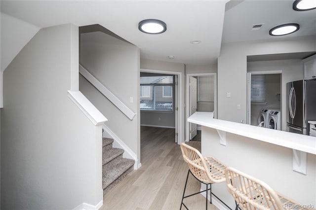 hall featuring washer and clothes dryer and light hardwood / wood-style flooring