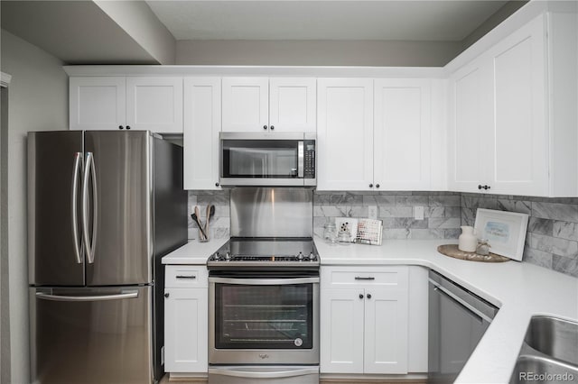 kitchen featuring backsplash, white cabinets, and stainless steel appliances