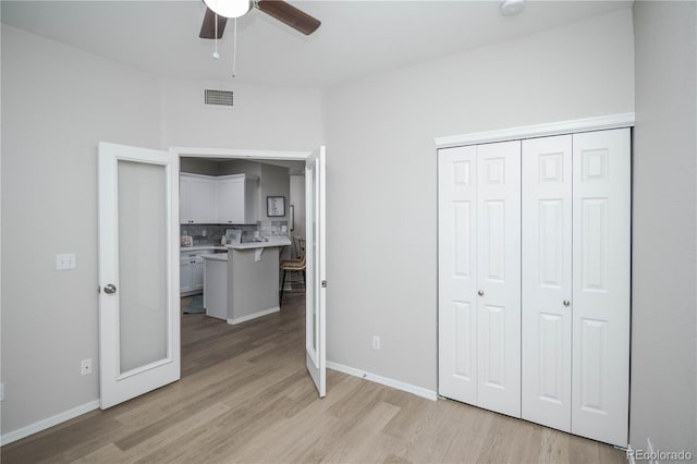 unfurnished bedroom featuring light wood-type flooring, a closet, and ceiling fan