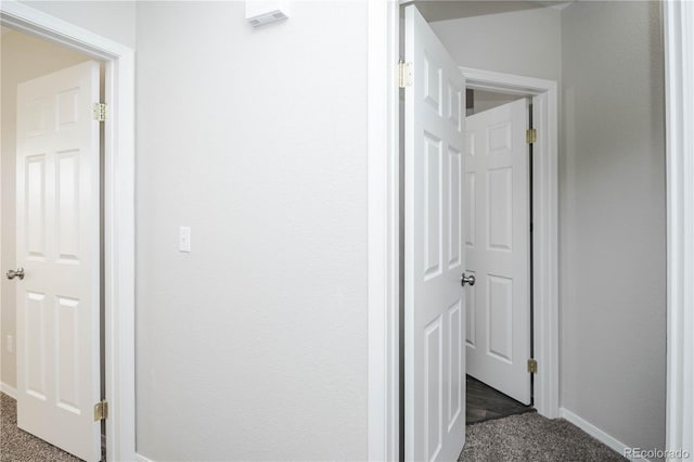 hall featuring dark colored carpet