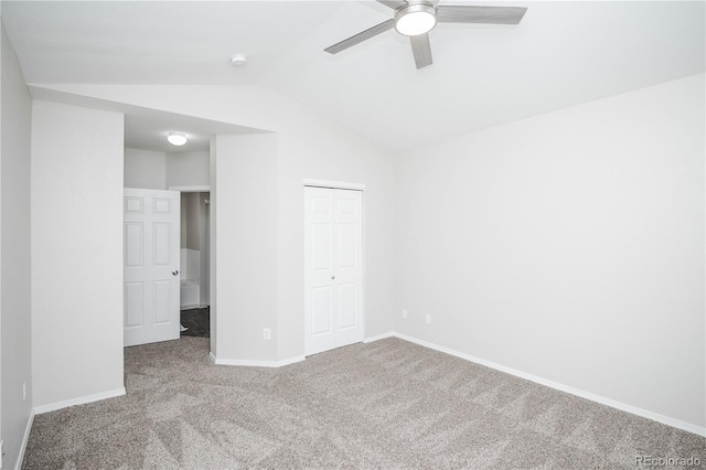 unfurnished bedroom with carpet floors, a closet, vaulted ceiling, and ceiling fan